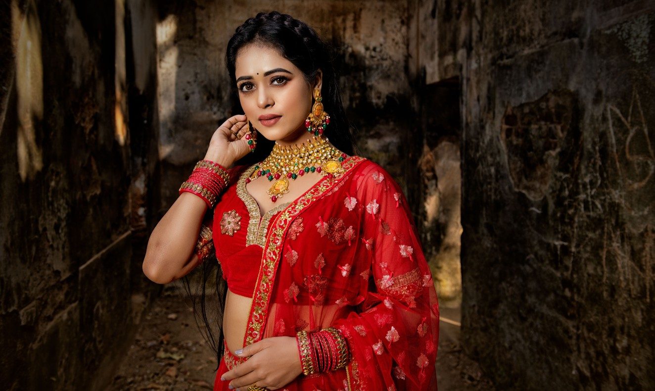Bride in red lehenga wearing a gold kundan choker and jhumkas